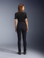 Alpinestars Stella Flex-Ast Leggings, motorleggings voor dames, zwart, achteraanzicht toont de hoge taille en slanke pasvorm, gedragen met zwarte top met korte mouwen en zwarte motorlaarzen, urban motorkleding