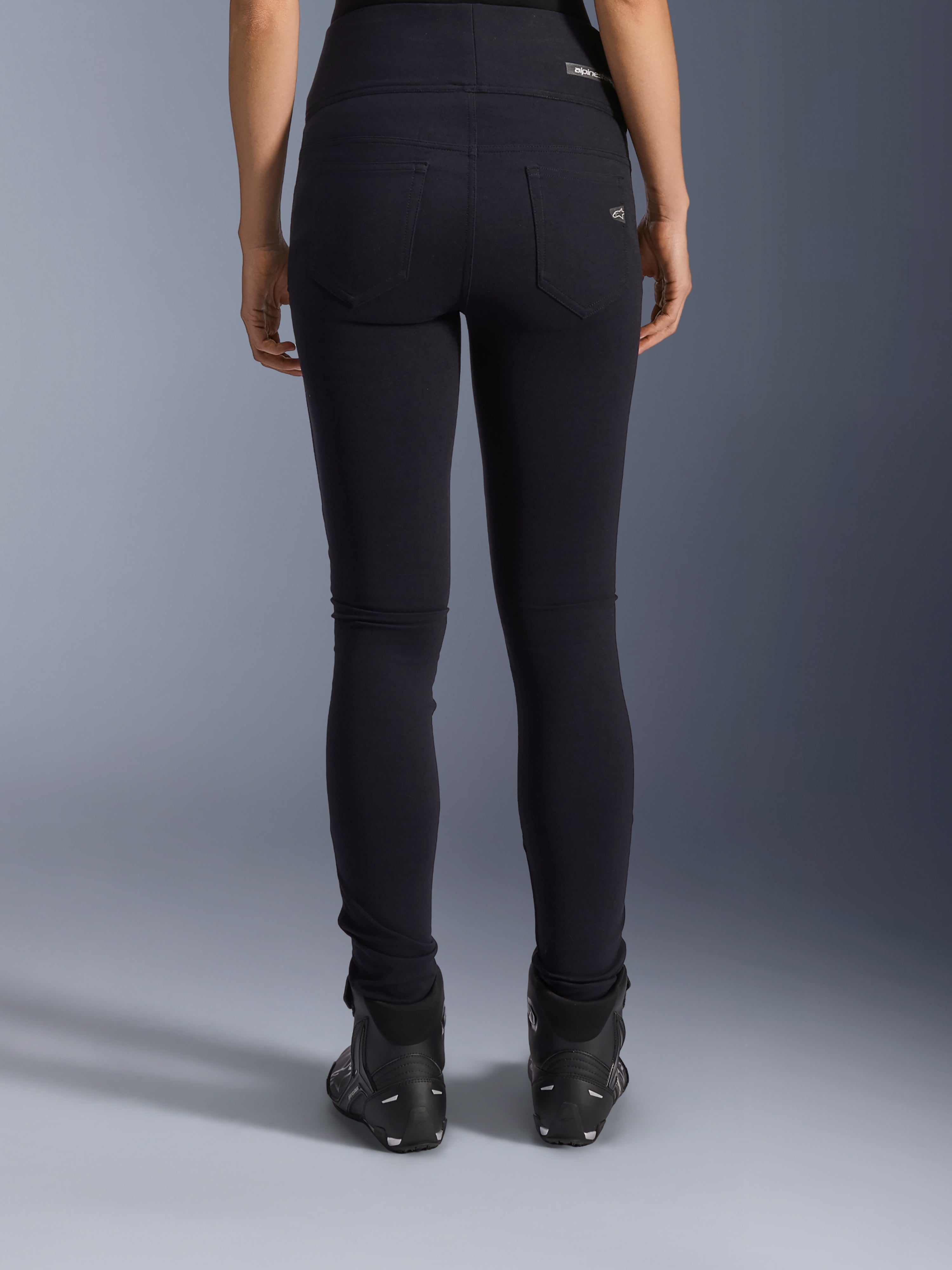 Alpinestars Stella Flex-Ast Leggings, dames motorlegging, zwart, achteraanzicht met achterzakken en slim fit pasvorm, gedragen met zwarte motorlaarzen, urban rijstijl