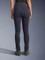Alpinestars Stella Flex-AST Leggings, pantalon de moto urbain, noir, vue arrière présentant une coupe skinny taille haute, deux poches arrière fonctionnelles avec un marquage subtil, matière textile extensible, porté avec des chaussures de moto noires.