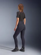 Legging Stella Flex-AST Alpinestars pour femme, legging de moto noir à taille haute, vue de dos montrant la coupe skinny et les poches arrière, porté avec un haut noir à manches courtes et des bottes de moto, tenue de moto urbaine pour femme