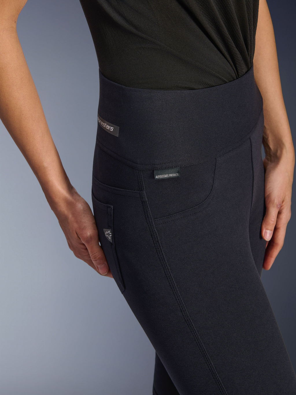 Alpinestars Stella Flex-Ast Leggings, motorlegging voor dames, zwart, close-up van de hoge tailleband en heupzone met subtiele merklogo's, strak stedelijk ontwerp voor op de weg