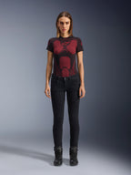 Alpinestars Daisy V3 Women's Riding Denim, Rinse Black, Slim-fit Motorcycle Pants, worn by a model with a red and black patterned technical t-shirt and black motorcycle boots, casual urban riding gear with a feminine silhouette and high-waisted design.