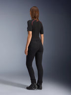Alpinestars Banshee dames leggings, zwart, achteraanzicht met nauwsluitende anatomische stretchpasvorm en achterzakken, gedragen met een zwart shirt met korte mouwen en motorlaarzen, stijlvolle urban motorkleding voor dames