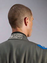 Alpinestars GP Race V3 Suit FIA in Anthracite Blue, detail view of the back collar showing the white FIA 8856-2018 homologation label, textile construction with blue shoulder accent.