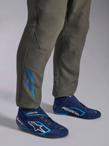Alpinestars GP Race V3 Suit FIA, Anthracite Blue auto racing suit, close-up of lower legs featuring a blue embroidered Astars logo at the ankle, paired with navy and cyan racing boots, professional motorsport protective gear