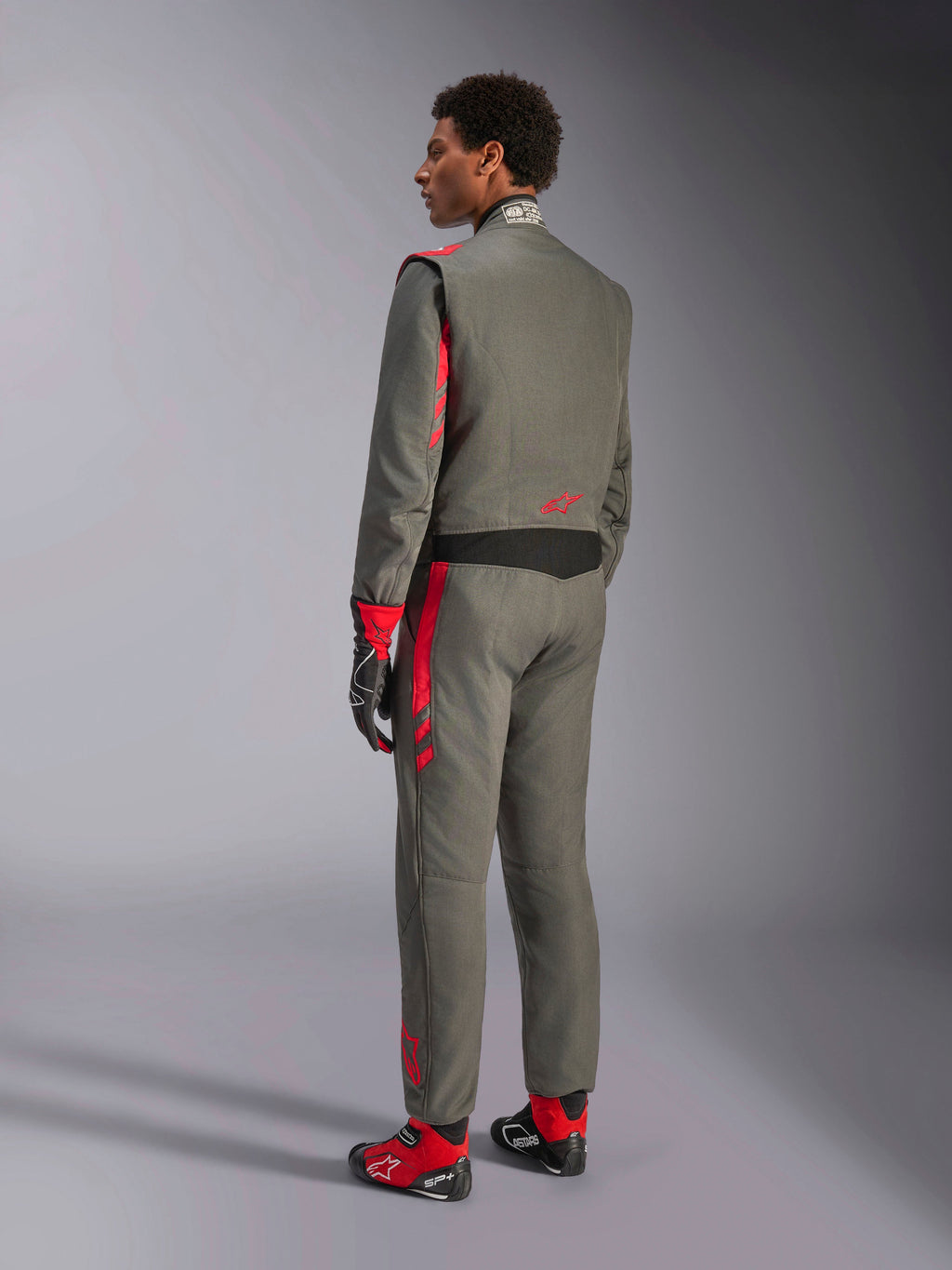 Alpinestars GP Race V3 Suit FIA, combinaison de course Anthracite Red, vue arrière du mannequin portant la combinaison double couche, accents rouges sur les épaules et les jambes, associée à des gants et des bottes assortis, équipement de course automobile professionnel
