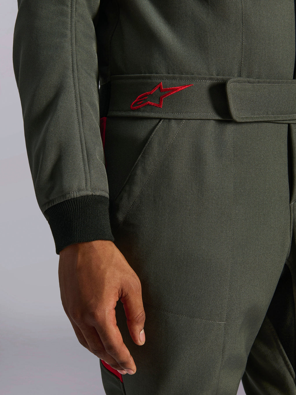 Combinaison Alpinestars GP Race V3 FIA, combinaison auto, Anthracite Rouge, gros plan sur la ceinture réglable arborant un logo brodé rouge et le poignet de manche côtelé noir sur tissu sergé texturé
