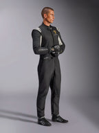 Pilote portant la combinaison Alpinestars Édition Limitée Lamborghini GP Tech V4, combinaison de course automobile certifiée FIA en noir, argent et or, avec gants et chaussures de course assortis, marquage Lamborghini Squadra Corse, équipement de sport automobile professionnel