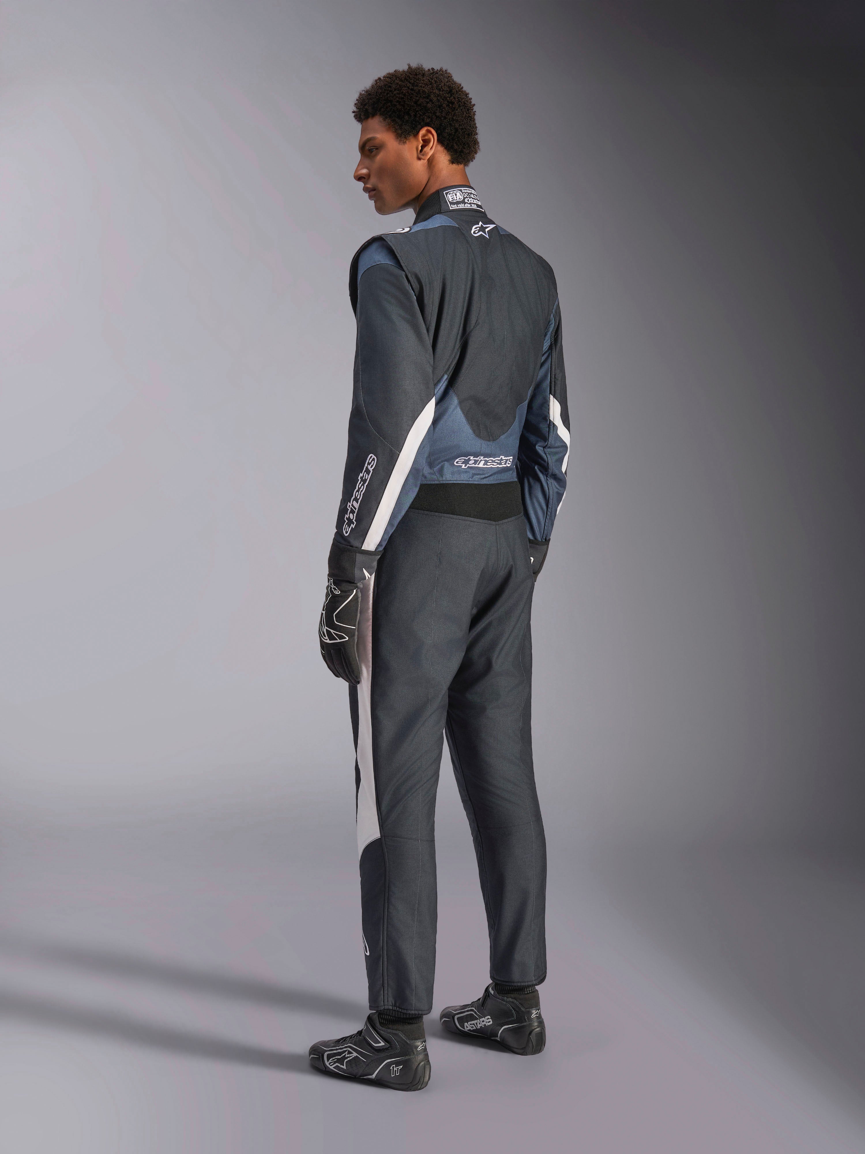 Alpinestars GP Pro Comp V2, combinaison de course automobile FIA pour homme, noire et asphalte, vue de profil arrière.