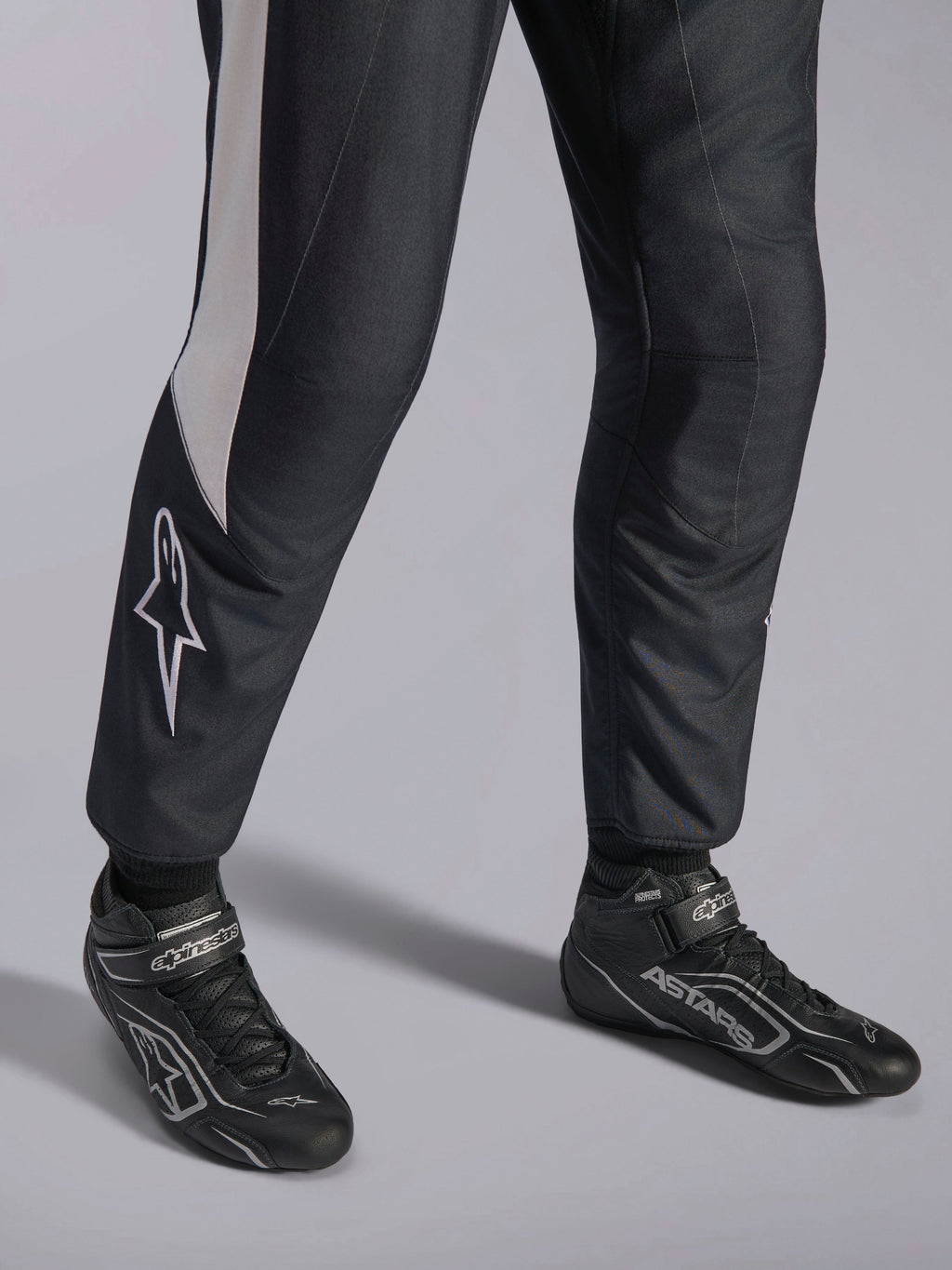 Combinaison Alpinestars GP Pro Comp V2 FIA, équipement auto noir et blanc et bottines de course professionnelles ASTARS.