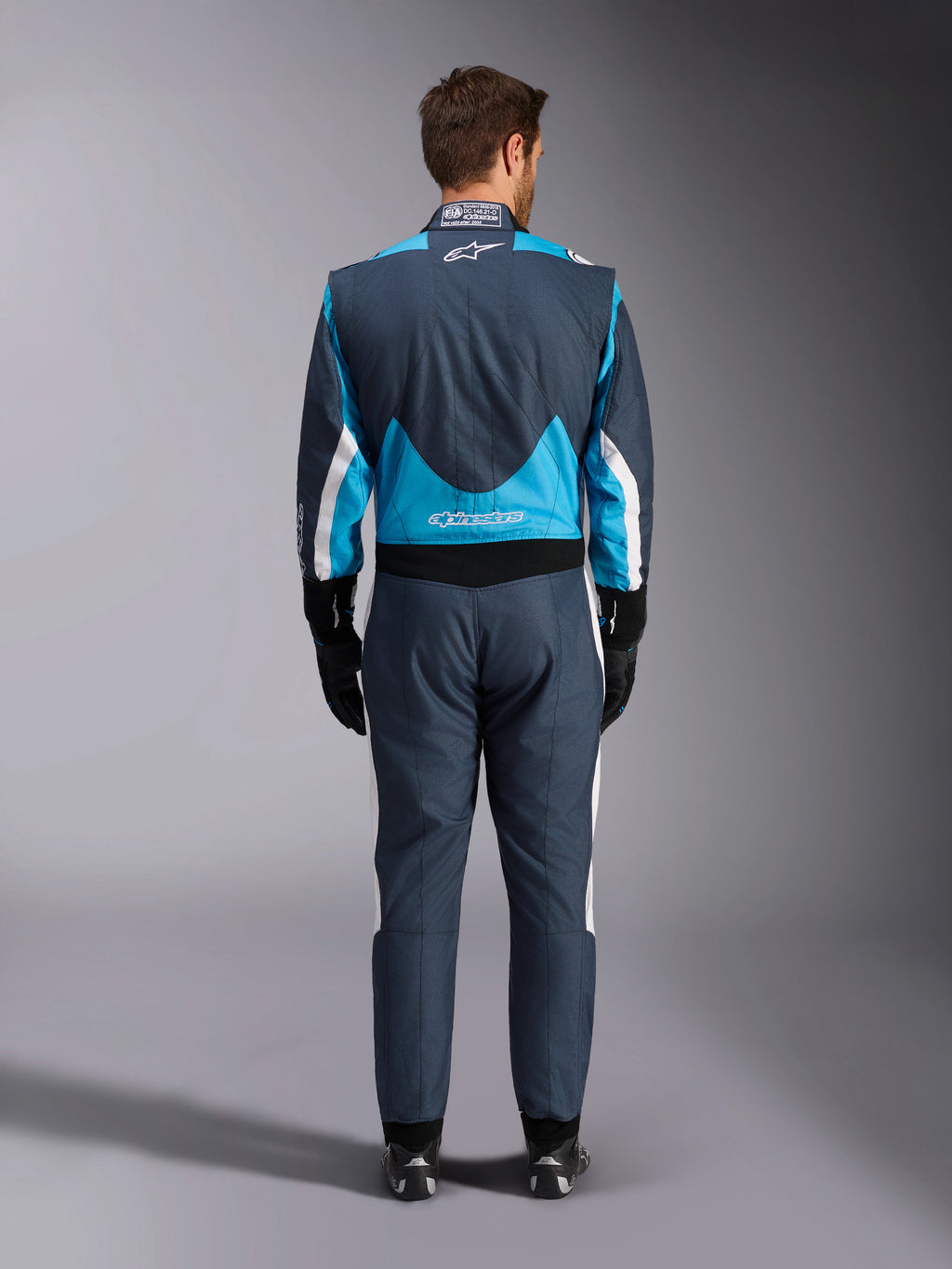 Combinaison Alpinestars GP Pro Comp V2 FIA, grise, bleue et blanche, vue arrière, protection de course automobile.