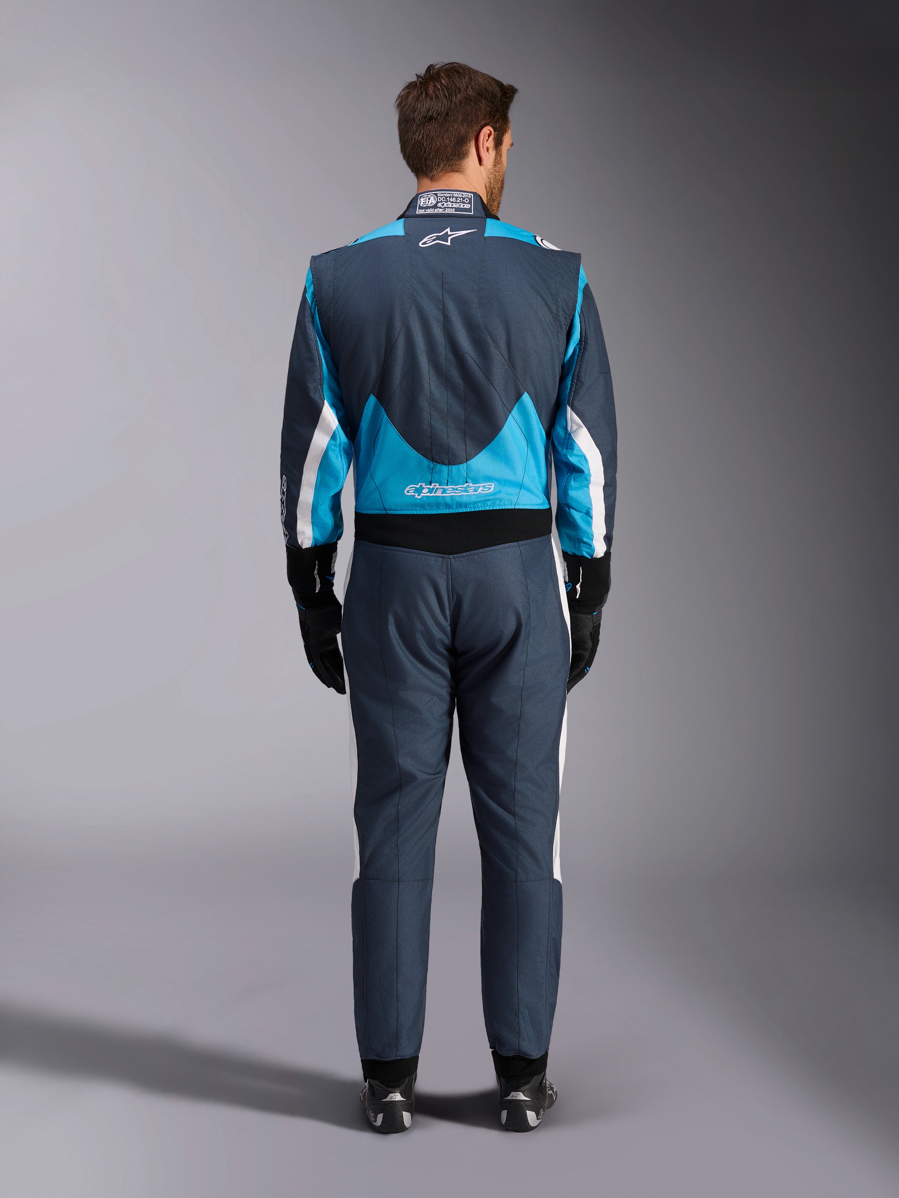 Combinaison Alpinestars GP Pro Comp V2 FIA, grise, bleue et blanche, vue arrière, protection de course automobile.