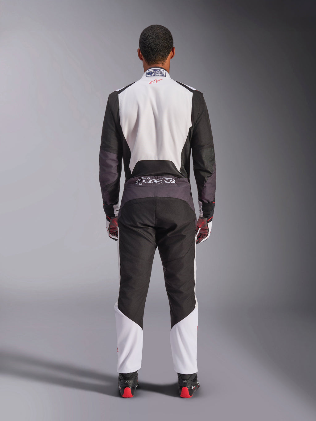 Alpinestars KMX-5 V3 Suit, Karting Suit, White Black and Bright Red, back view, one-piece racing suit with breathable mesh panels and Alpinestars logo on the waist, worn with matching racing gloves and boots