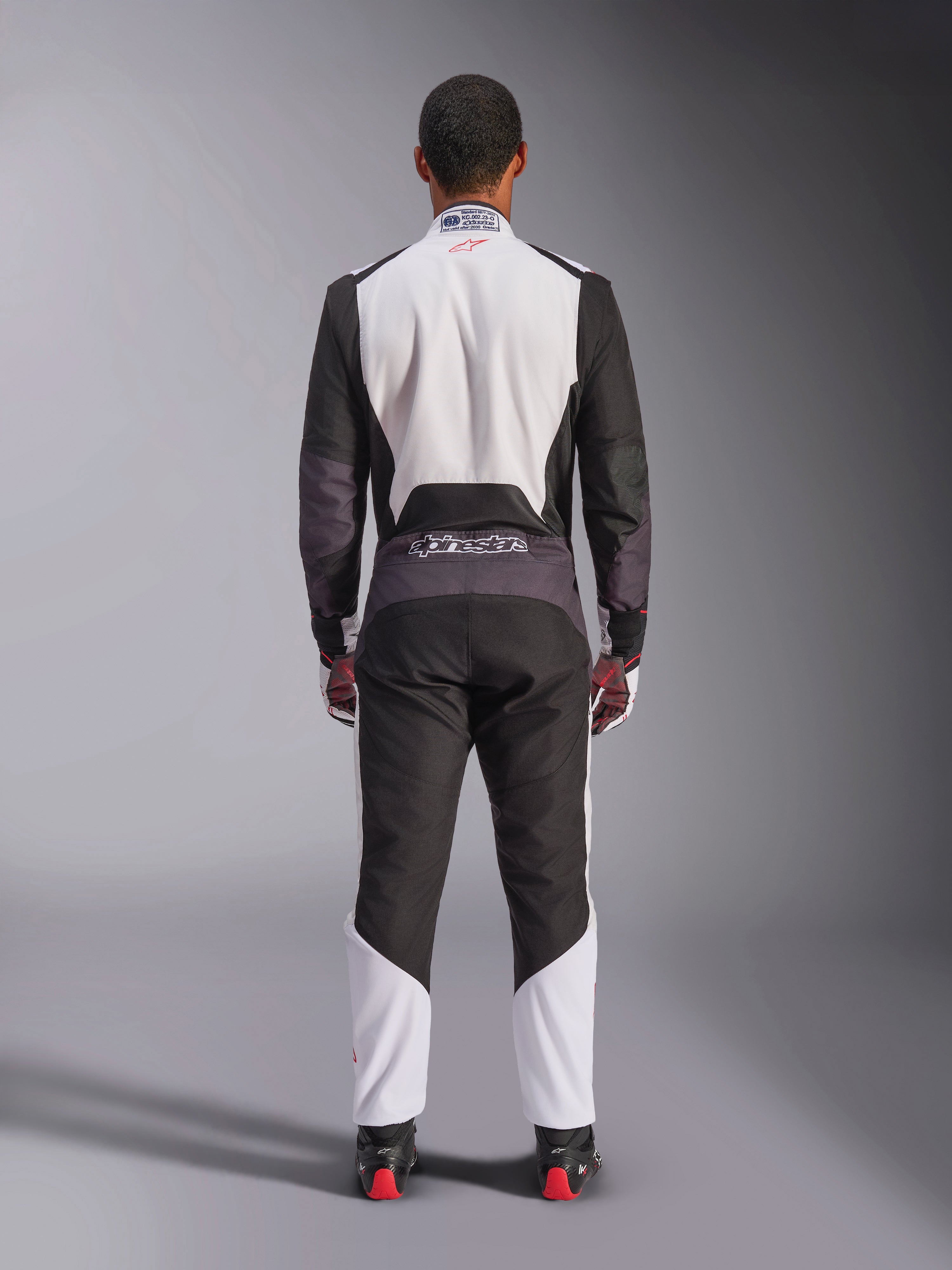 Alpinestars KMX-5 V3 Suit, Karting Suit, White Black and Bright Red, back view, one-piece racing suit with breathable mesh panels and Alpinestars logo on the waist, worn with matching racing gloves and boots