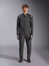 Combinaison Alpinestars GP Tech V4, noir et blanc, combinaison de course automobile professionnelle une pièce, portée avec des gants et des bottines de course assortis noirs et blancs, avec logos Alpinestars blancs sur les épaules et le col, coupe athlétique élégante pour la compétition automobile