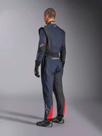 Alpinestars GP Tech V4 Pak, navyblauw zwart rood, achteraanzicht van professioneel eendelig autoracepak met rode accenten en zwarte panelen, gedragen met zwarte racehandschoenen en schoenen, FIA-gecertificeerde motorsportuitrusting