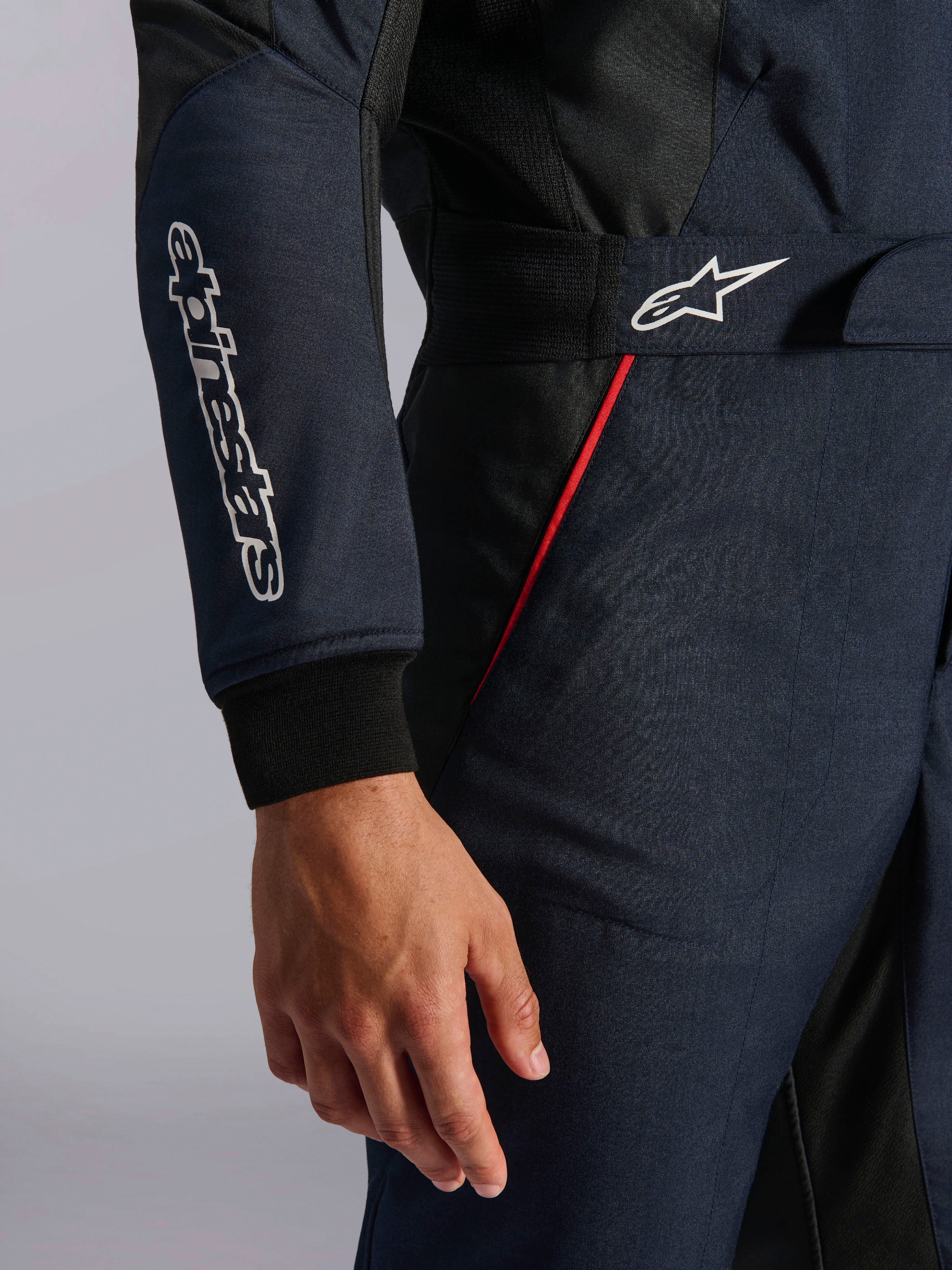 Alpinestars GP Tech V4-pak in Blue Navy Black Red, detailopname van de taille en mouw met witte Alpinestars-logo's, rode accentbies en getextureerde keperstof.