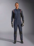 Alpinestars GP Tech V4 Suit, professioneel autoracepak in donkerblauw en zwart met rode biezen, eendelig FIA-gecertificeerd racepak, gedragen met zwarte racehandschoenen en raceschoenen, motorsport kleding voor coureurs