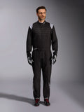 Alpinestars KMX-9 V3 Suit, Black and White Karting Suit, full-length view on a model, featuring white shoulder logos and accents, styled with black and white racing gloves and black shoes with red laces, athletic-regular fit for professional karting gear.