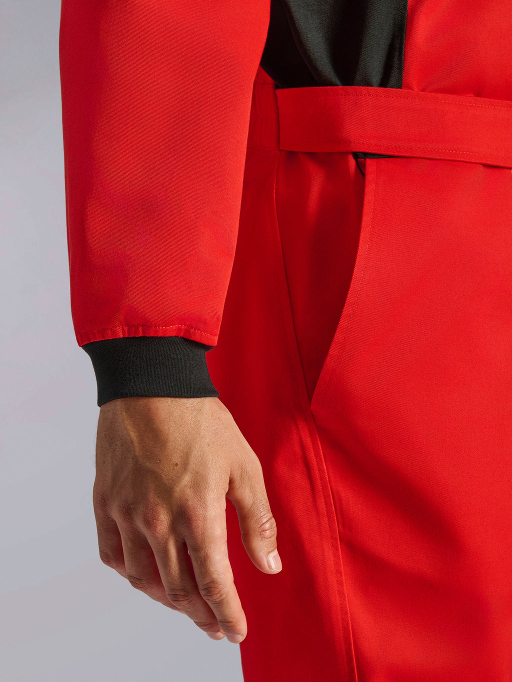 Alpinestars Kart Indoor V2 Suit, Red karting suit, close-up showing black knitted wrist cuff, adjustable waist belt, and durable single-layer twill material