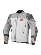 Alpinestars Nazca 3L GORE-TEX PRO Jacket, Adventure Motorcycle Jacket, Dark Gray and Mid Gray with orange zipper accents, featuring All Terra chest logo, Superfabric reinforcements on shoulders and elbows, multiple zippered ventilation openings, rugged touring design