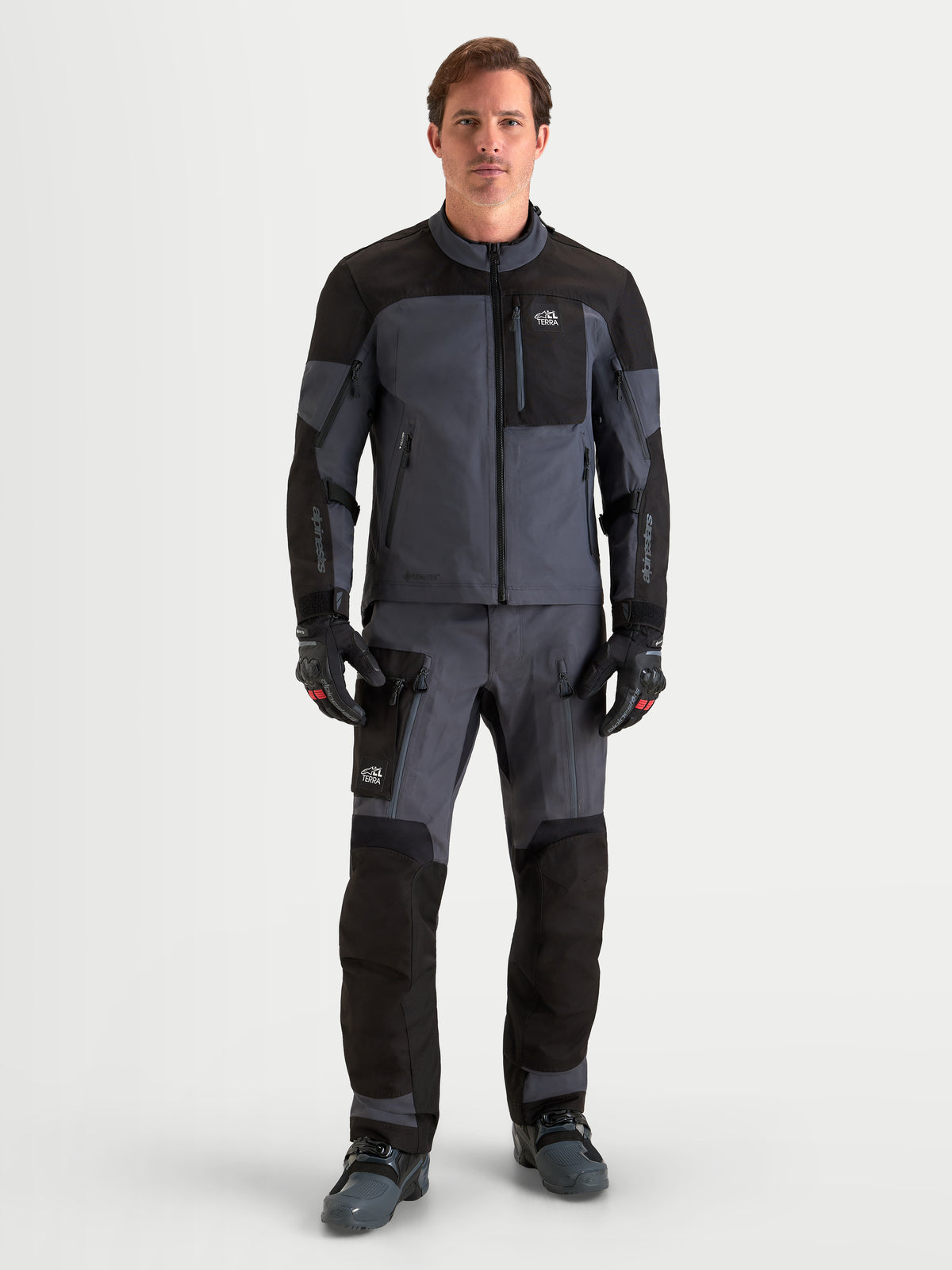 Alpinestars Arenis Gore-Tex Gear Set, adventure motoruitrustingsset voor heren in zwart en donkergrijs, volledig vooraanzicht op een model in waterdichte all-terrain motorkleding