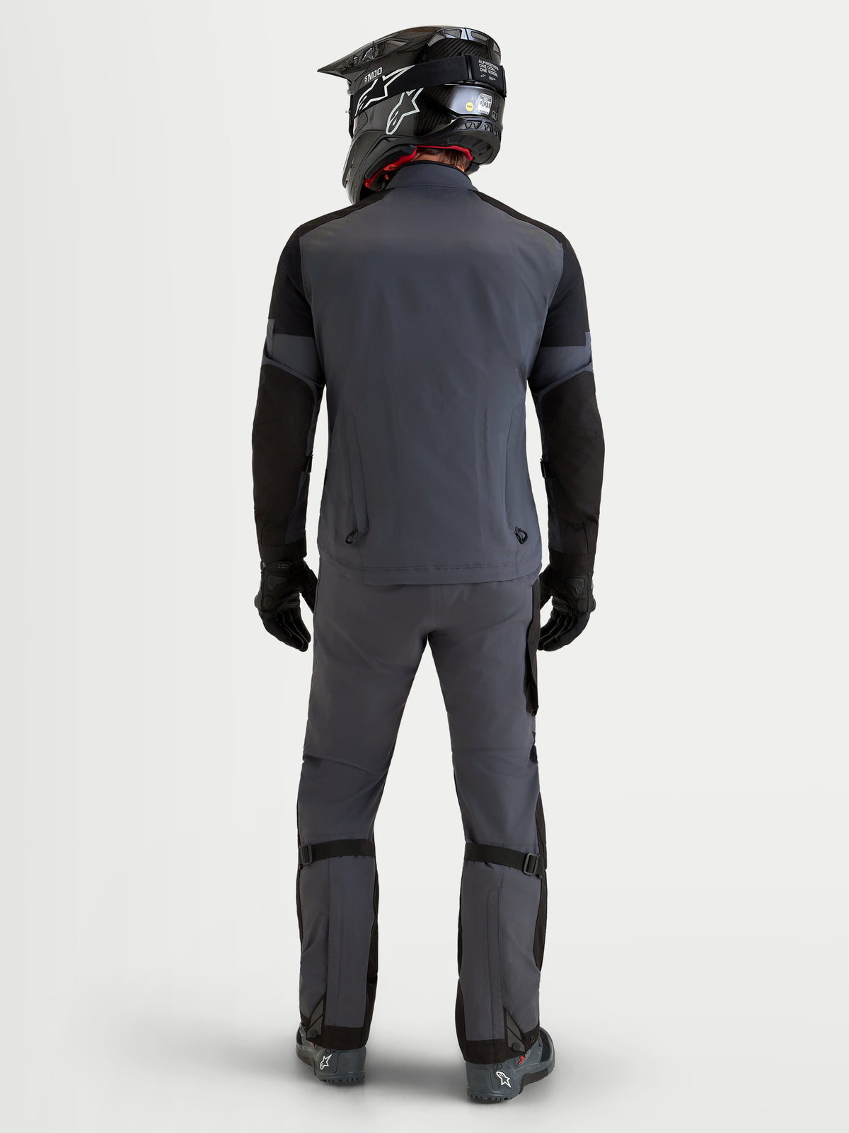 Alpinestars Arenis Gore-Tex Gear Set, adventure motorpak voor heren in donkergrijs en zwart, achteraanzicht op een model met een bijpassende helm en uitrusting, waterdichte GORE-TEX all-terrain kleding