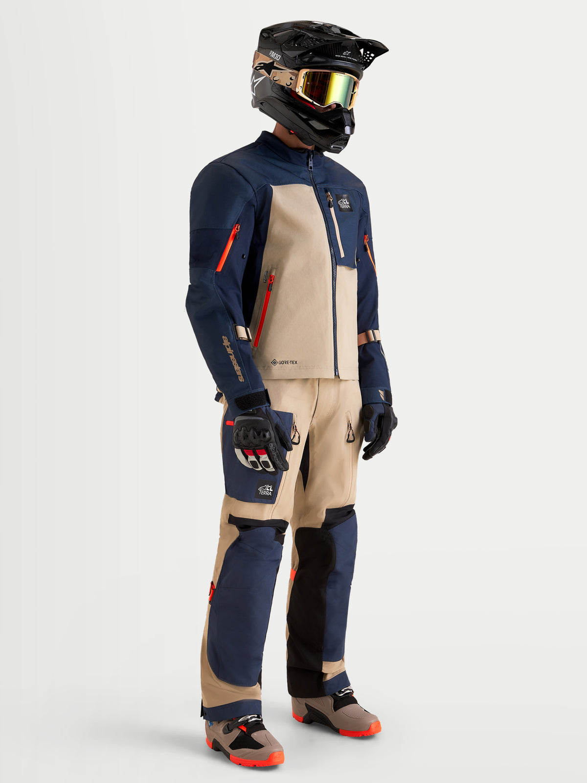 Alpinestars Tenue complète Arenis Gore-Tex, veste et pantalon de moto adventure pour homme en bleu nuit et aluminium, vue de profil sur un modèle portant l'équipement assorti et un casque, tenue d'équitation imperméable certifiée AA