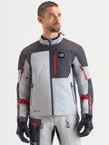 Alpinestars Arenis Gore-Tex jas, heren adventure motorjas in middengrijs, donkergrijs en zwart, vooraanzicht gedragen door een model met waterdichte textielconstructie en borstzak met rits