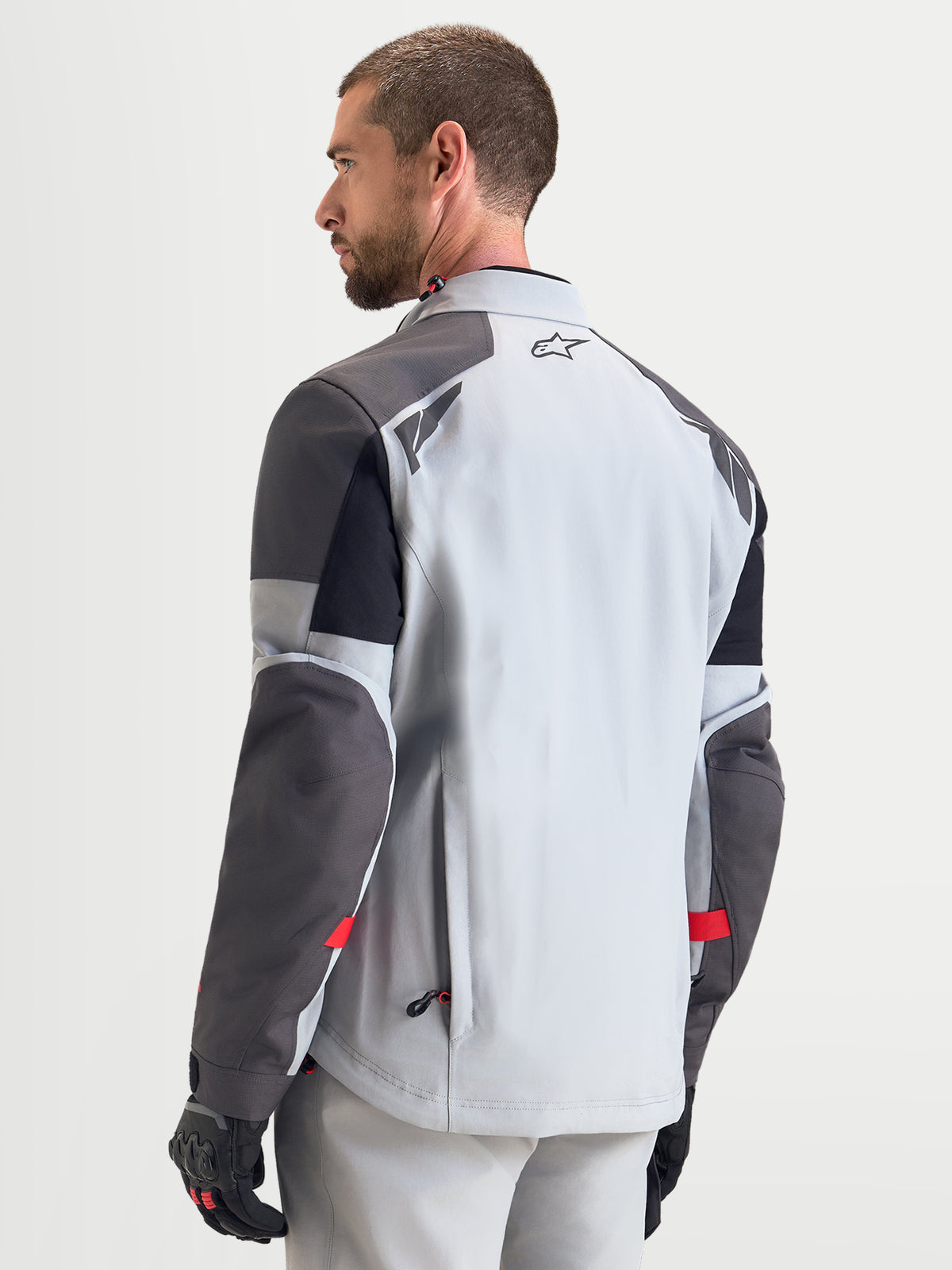 Alpinestars Arenis Gore-Tex jas, heren adventure motorjas in middengrijs, donkergrijs en zwart, achteraanzicht op model met waterdichte textielconstructie en reflecterende details