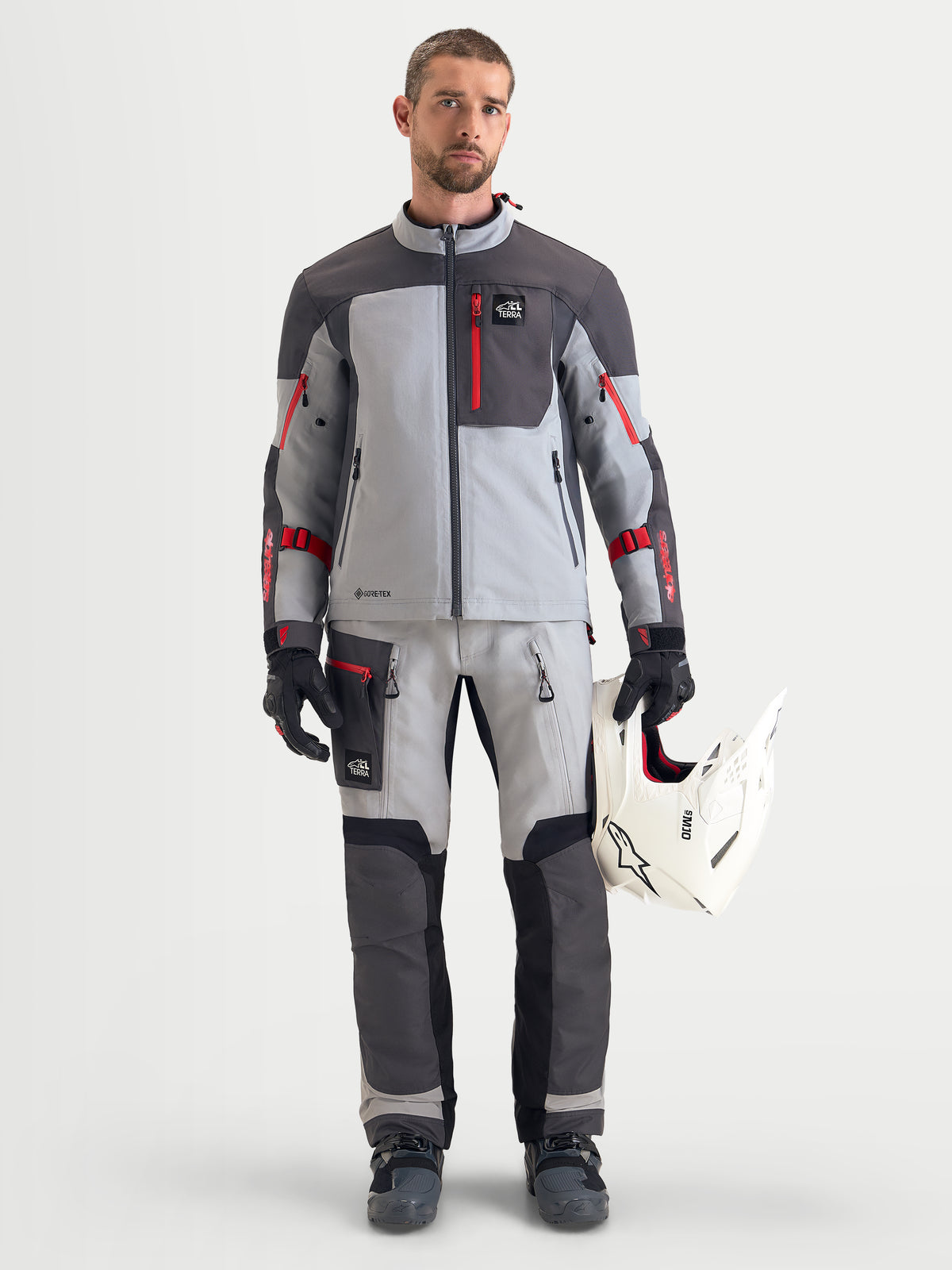 Alpinestars Arenis Gore-Tex jas, adventure touring motorjas voor heren in middengrijs, donkergrijs en zwart, gedragen door een model met een witte helm