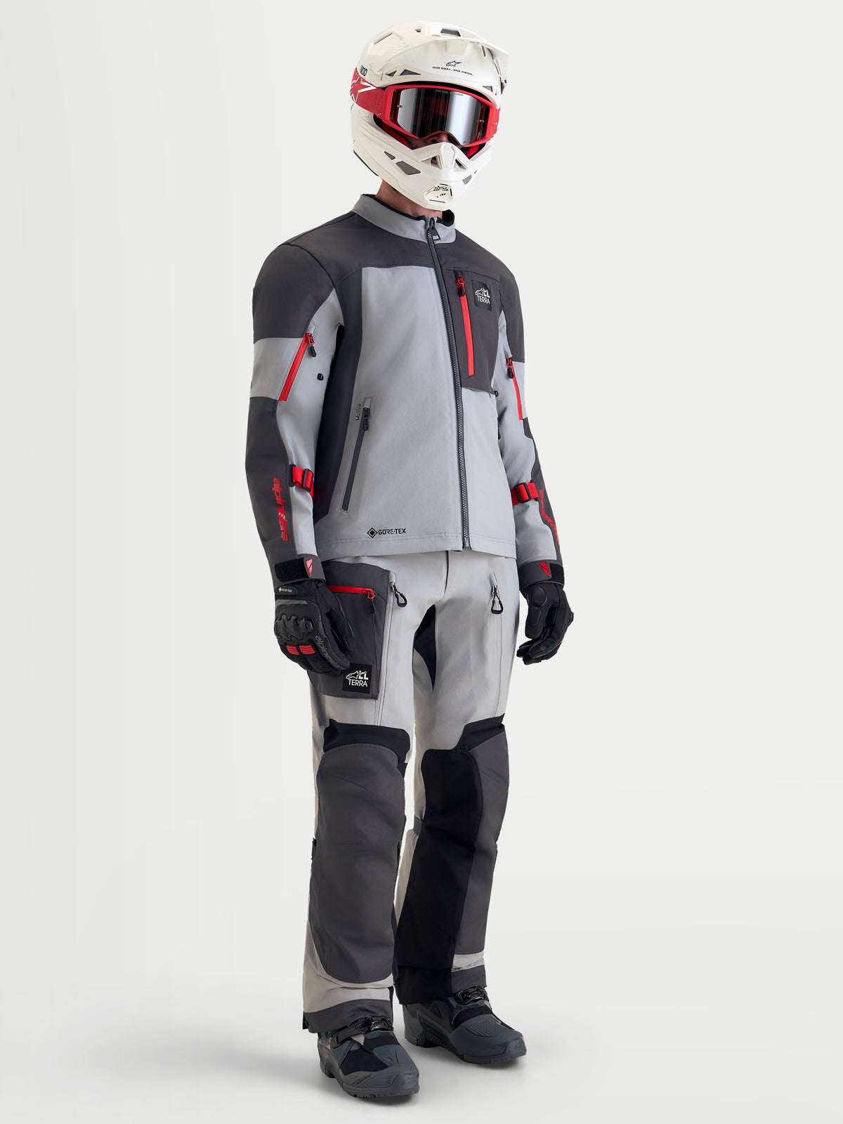 Alpinestars Arenis Gore-Tex jas, heren adventure motorjas in middengrijs, donkergrijs en zwart met rode accenten, complete uitrusting met bijpassende broek, helm en veiligheidsbril op model