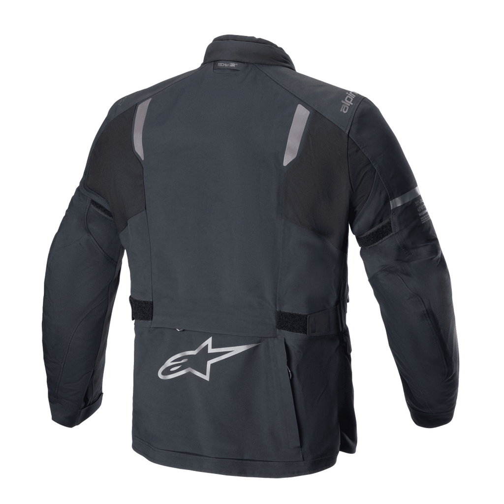 Alpinestars ST-7 2L GORE-TEX jas, achteraanzicht, zwart en donkergrijs, met reflecterende schouderpanelen, zilveren Alpinestars sterlogo op de onderrug en verstelbare taillebanden, adventure touring motorkleding