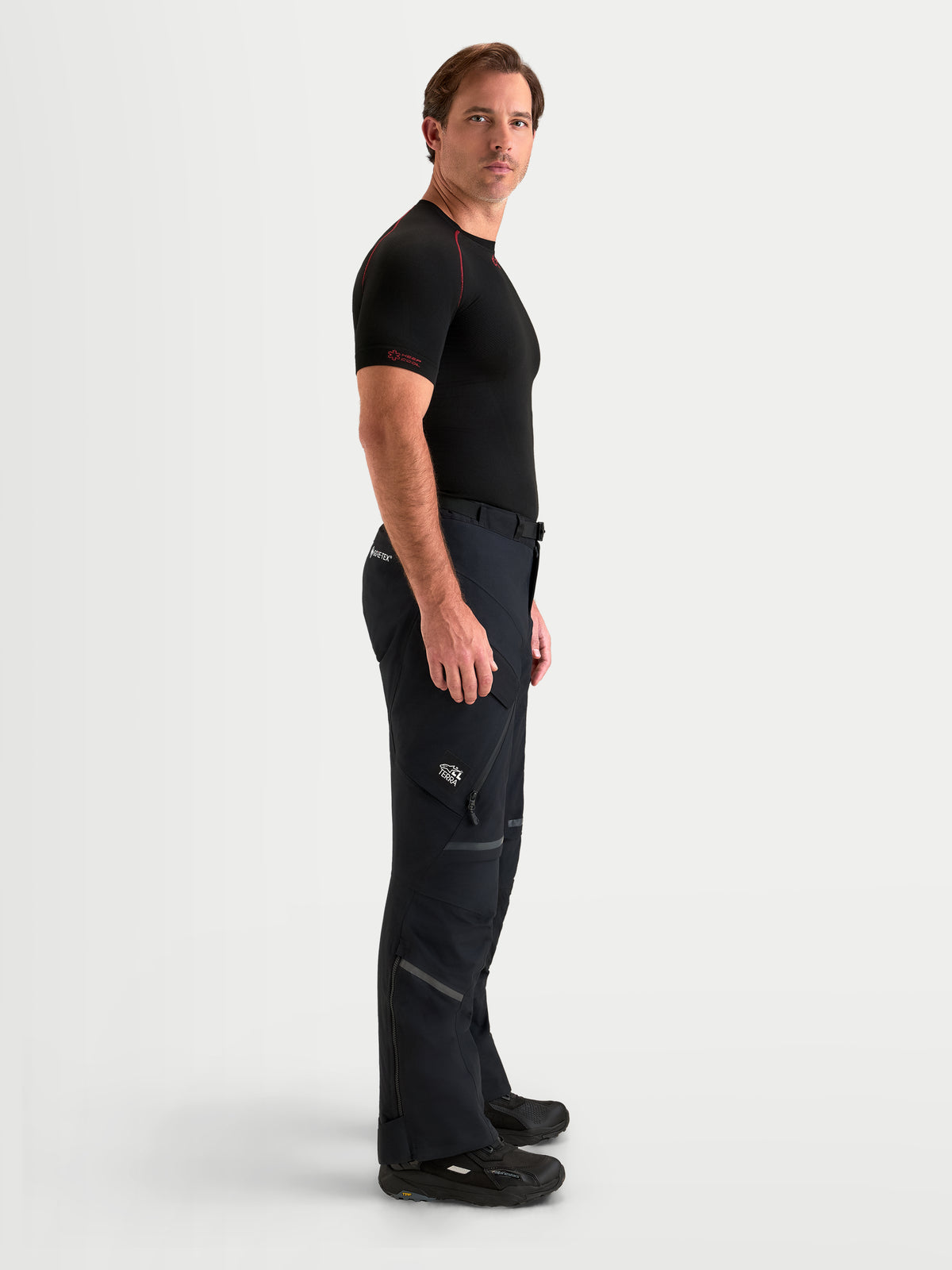 Alpinestars St 7 V 2 2 L Gore Tex Pantalons, pantalon de moto adventure pour homme noir, vue de profil latéral porté par un modèle montrant la construction en textile imperméable et les poches cargo