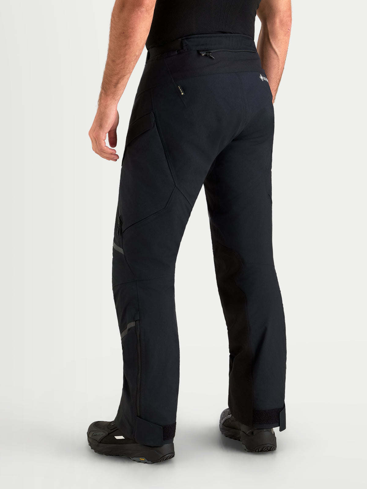Alpinestars Pantalon St-7 V2 2L Gore-Tex, pantalon de moto adventure pour homme noir, vue de dos sur un modèle montrant la construction textile imperméable et les zips sur le bas des jambes