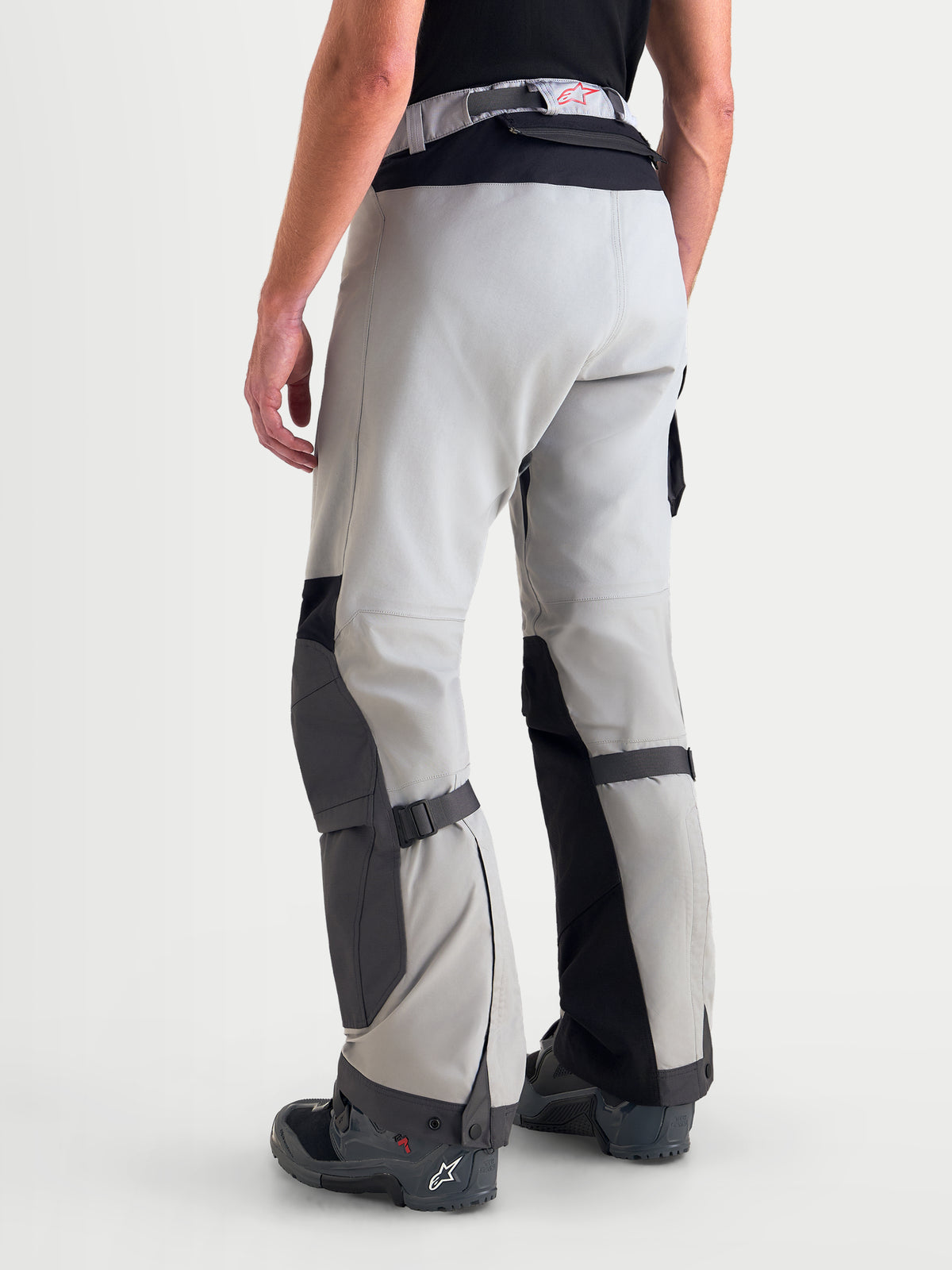 Alpinestars Arenis Gore-Tex broek, avontuurlijke motorbroek voor heren in middengrijs, donkergrijs en zwart, achteraanzicht op model met waterdichte textielconstructie en versterkte knie- en zitvlakzones