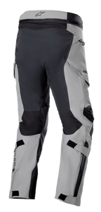Alpinestars Boulder 3L GORE-TEX broek, adventure motorbroek, donkergrijs en zwart, driekwart achteraanzicht met versterkt zitvlak en binnenzijde van de benen, lichtgrijze panelen, GORE-TEX logo op de kuit en ergonomische cargozakken.
