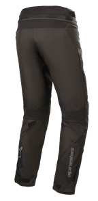 Pantalon Alpinestars Road Pro GORE-TEX, pantalon de moto noir, vue arrière montrant la coupe touring ajustée, construction textile technique, marquage Alpinestars sur le bas de la jambe, panneaux extensibles en accordéon et sangles de réglage pour le touring aventure.