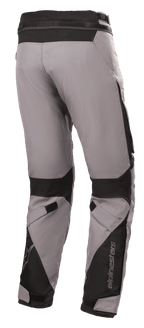 Pantalon Alpinestars Road Pro GORE-TEX, pantalon de touring moto, gris foncé et noir, vue arrière avec construction en textile technique, renforts en nylon balistique noir, sangles réglables aux genoux et aux chevilles, et logo Alpinestars.