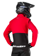 Alpinestars Pro-Dura jas, off-road enduro jas, rood en zwart met wit Alpinestars-logo op de achterzoom, van achteren gezien gedragen door een rijder met een zwarte motorcrosshelm, rally-geïnspireerd ontwerp voor agressief trailrijden