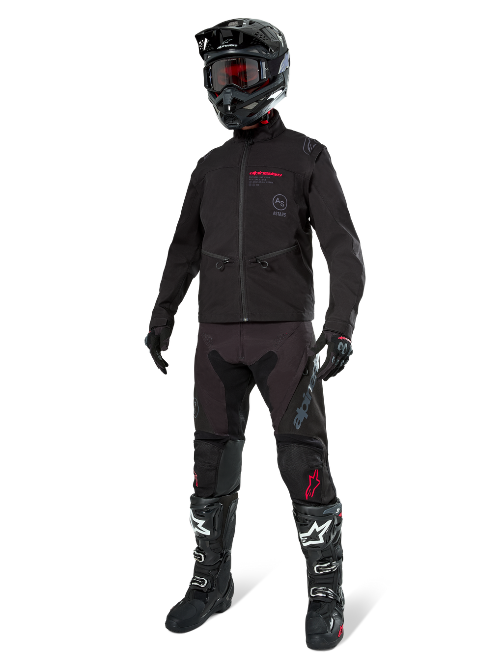 Veste Softshell Lite-Dura Alpinestars, noire, portée par un mannequin avec une tenue complète tout-terrain comprenant un pantalon noir, des bottes noires et blanches, un casque noir avec des lunettes rouges, équipement professionnel de motocross et d'enduro.