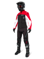 Pilote de motocross portant la veste Alpinestars Lite-Dura Softshell en noir, rouge vif et blanc, avec corps noir et manches rouges et blanches, pantalon noir, casque noir avec lunettes rouges et bottes noires et blanches, tenue de course tout-terrain complète