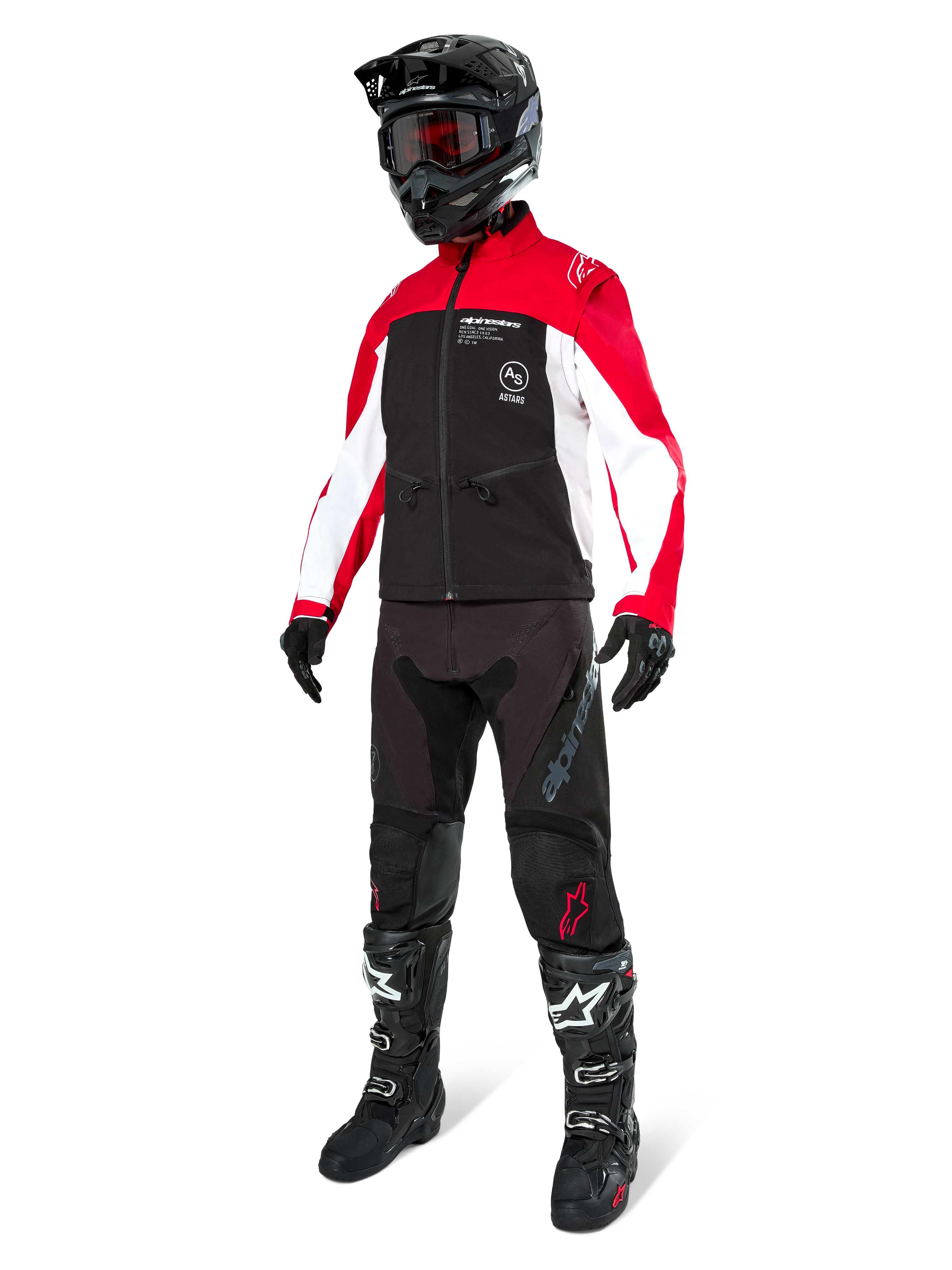 Pilote de motocross portant la veste Alpinestars Lite-Dura Softshell en noir, rouge vif et blanc, avec corps noir et manches rouges et blanches, pantalon noir, casque noir avec lunettes rouges et bottes noires et blanches, tenue de course tout-terrain complète