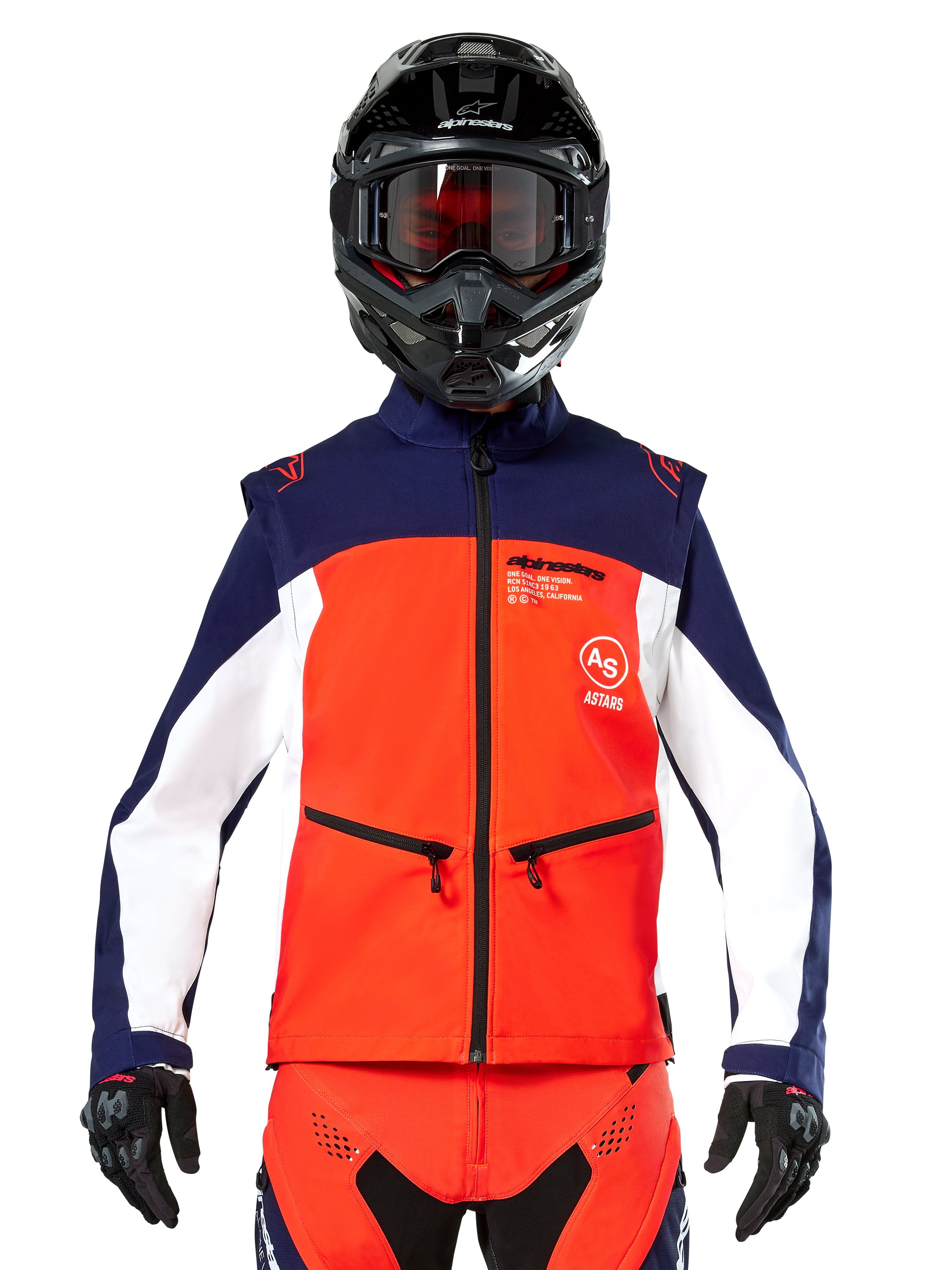 Veste Softshell Alpinestars Lite-Dura en bleu marine, orange vif et blanc, vue de face sur un pilote portant un casque noir et des lunettes, design technique à blocs de couleurs avec poches zippées et logos Alpinestars, équipement polyvalent pour l'enduro et le tout-terrain