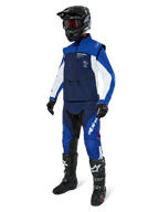 Alpinestars Lite-Dura Softshell Jacket, Navy Bright Blue and White, worn with matching off-road pants, black motocross boots, black helmet with goggles, and black gloves, complete enduro gear for off-road racing