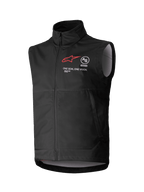 Gilet Softshell Techstar Alpinestars, gilet de motocross noir sans manches, col montant avec fermeture éclair frontale, logo étoile rouge avec marquages "ASTARS" et "ONE GOAL. ONE VISION." sur la poitrine, tissu softshell léger et coupe-vent avec doublure gris clair, conçu pour le tout-terrain