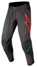 Alpinestars Techstar Phantom Pants, pantalon de motocross, anthracite et vert fluo, avec un grand logo d'étoile rouge sur la cuisse gauche, marquage ASTARS vert sur le côté, empiècements de genoux noirs renforcés, fermeture à cliquet réglable à la taille, équipement de performance durable pour le motocross