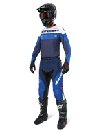 Motocross-Fahrer in Alpinestars Pro-Dura Hose in Navy, Hellblau und Weiß, kombiniert mit passendem Langarm-Trikot, schwarzem Helm mit roter Brille, schwarzen Handschuhen und schwarz-weißen Stiefeln, abgestimmtes Outfit für Enduro- und Offroad-Rennsport.