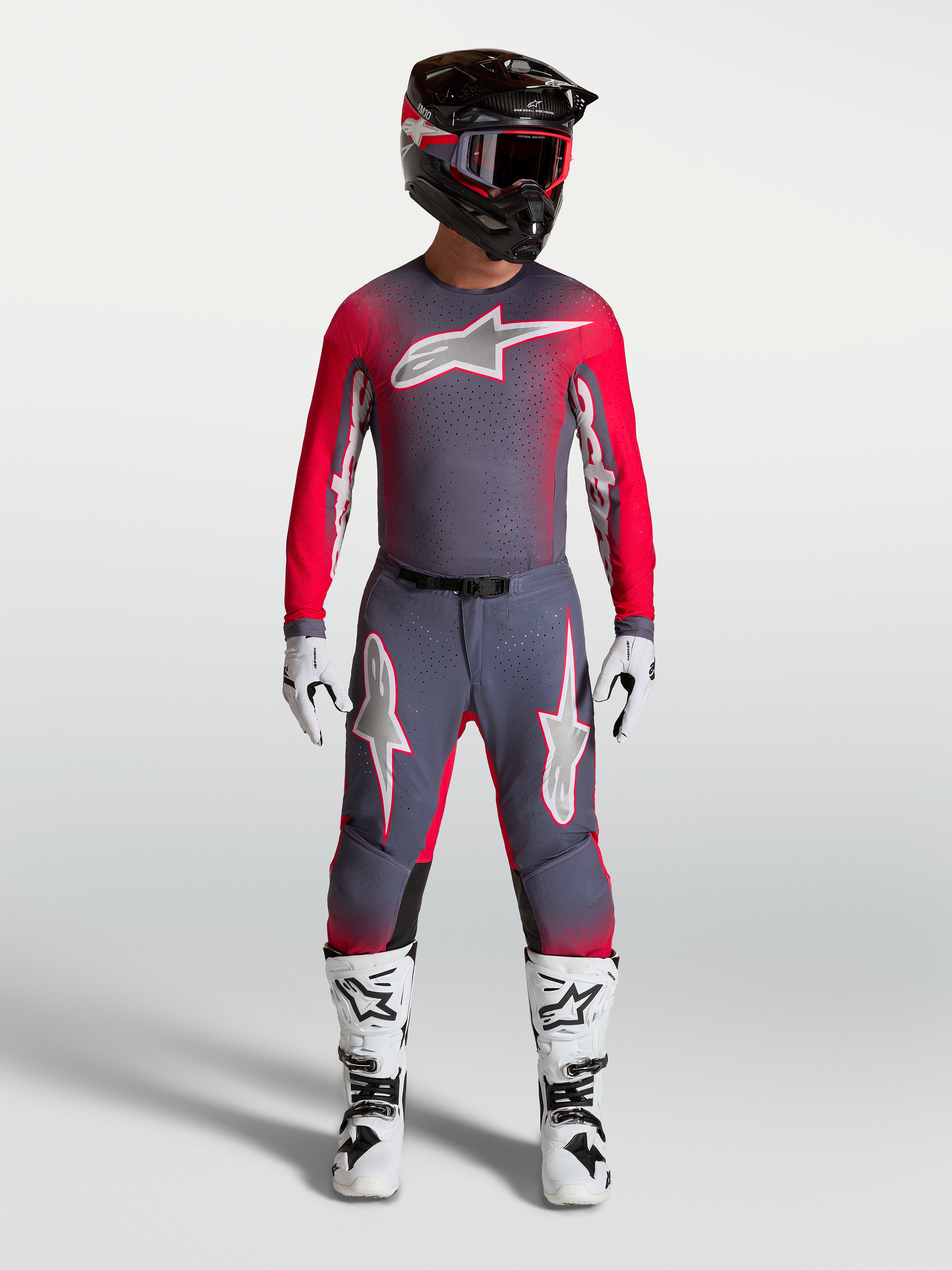 Alpinestars Supertech Hiten AFD Gear Set und Hose, professionelle Motocross-Bekleidung in Grau und Rot-Fluo, athletische Rennpassform für Elite-Fahrer.