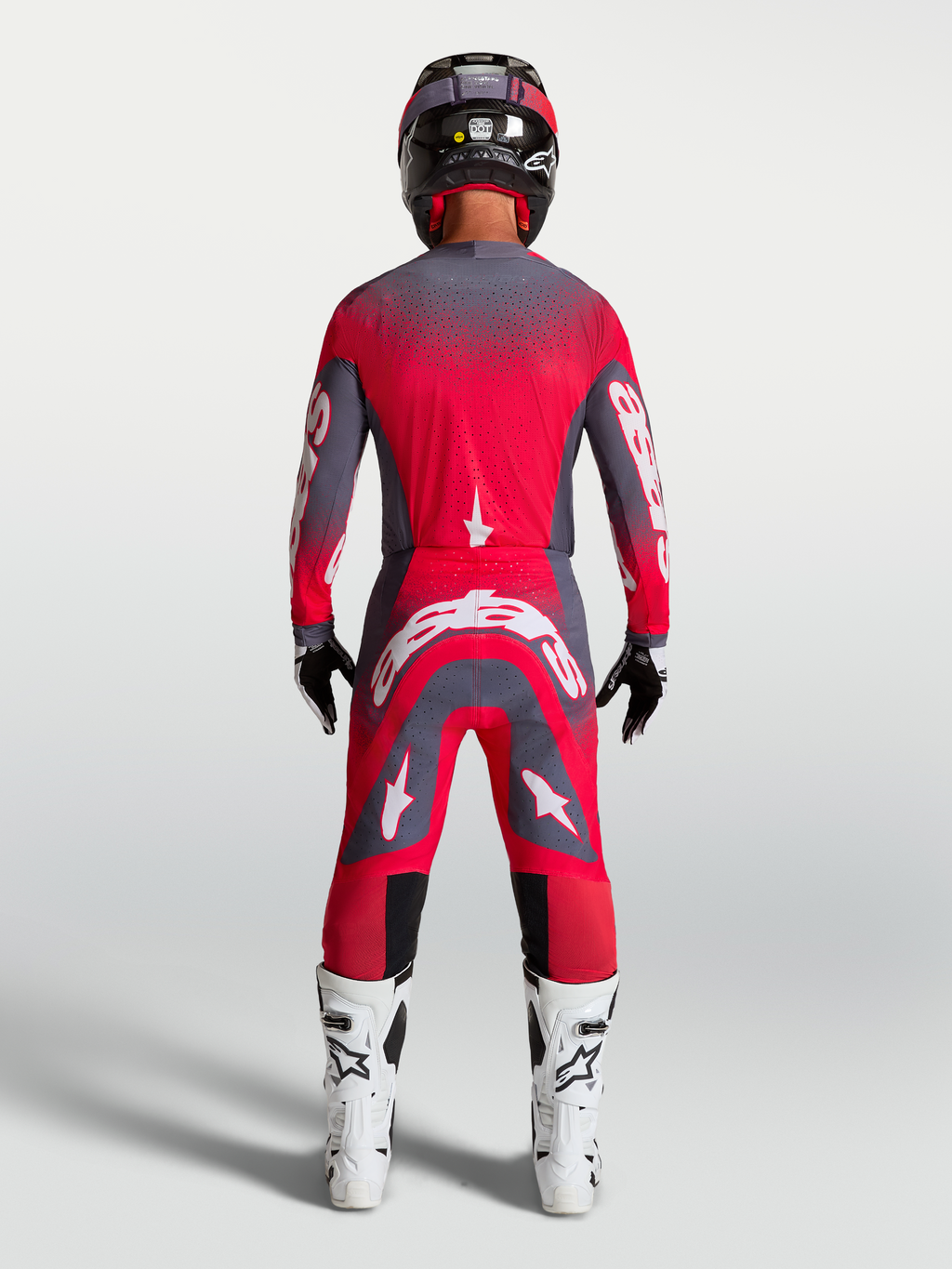 Alpinestars Supertech Hiten AFD gearset en broek, motocross racinguitrusting in neonrood en grijs, achteraanzicht op model.